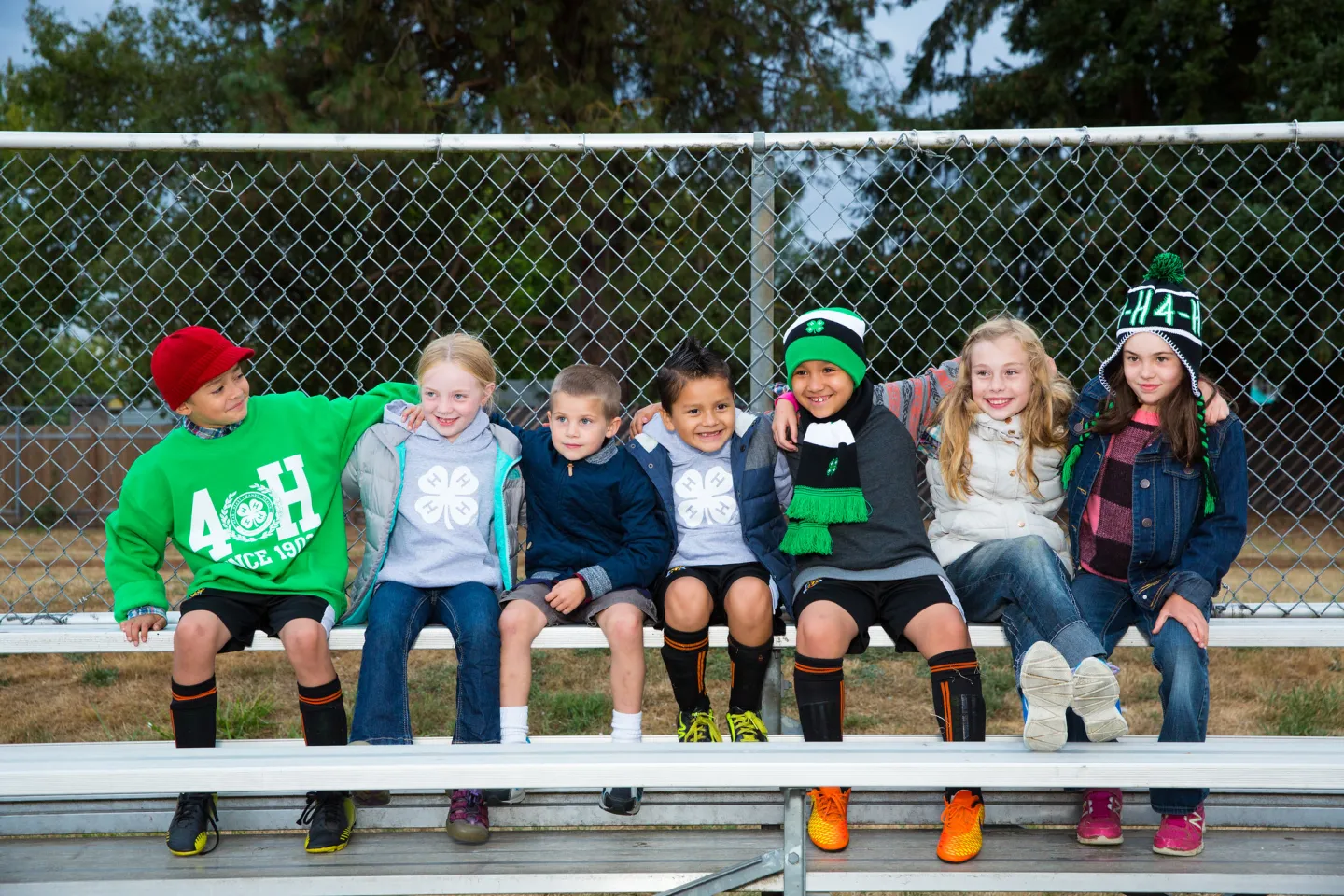 Group of Primary youth sitting next to each other on a bleacher